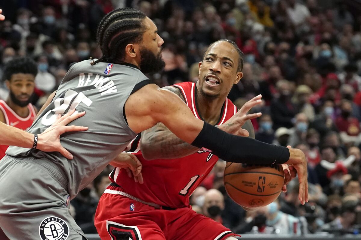 Brooklyn Nets' DeAndre' Bembry (95) slaps the ball away from Chicago Bulls' DeMar DeRozan during the second half of an NBA basketball game Wednesday, Jan. 12, 2022, in Chicago. The Nets won 138-112. (AP Photo/Charles Rex Arbogast)