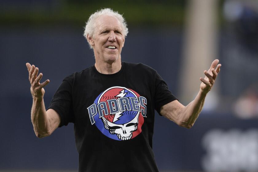 FILE - Former basketball player and sportscaster Bill Walton gestures after throwing out the ceremonial first pitch before a baseball game between the San Diego Padres and the Colorado Rockies Thursday, Aug. 8, 2019, in San Diego. Bill Walton might have been the ultimate San Diegan. While he went away to play basketball at UCLA as well as the bulk of his NBA career, he never missed a chance to celebrate his hometown. (AP Photo/Orlando Ramirez, File)