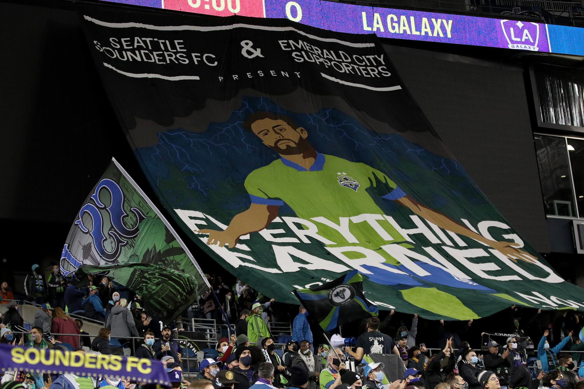 Sounders fans hold a banner before a game against LAFC earlier this season.