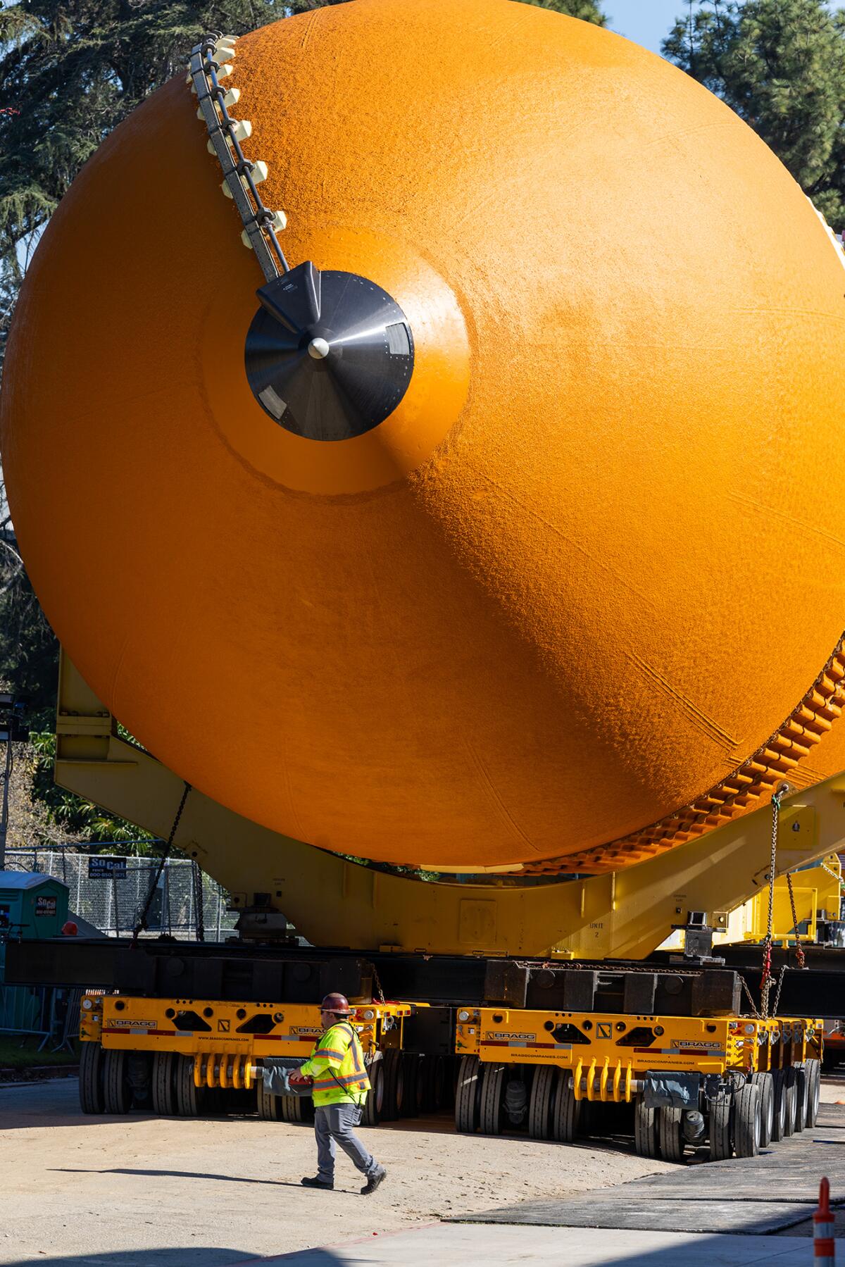 A crew member is dwarfed by the ET-94 space shuttle tank at the California Science Center.
