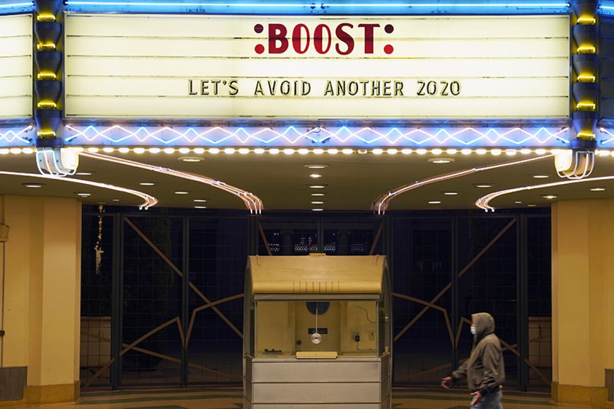 A man walks underneath the marquee of the Alex Theatre in Glendale. 