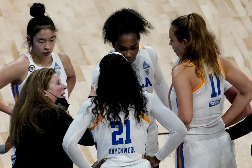 UCLA head coach Cori Close talks to her players during the first half of a college basketball game against Texas in the second round of the women's NCAA tournament at the Alamodome in San Antonio, Wednesday, March 24, 2021. (AP Photo/Charlie Riedel)