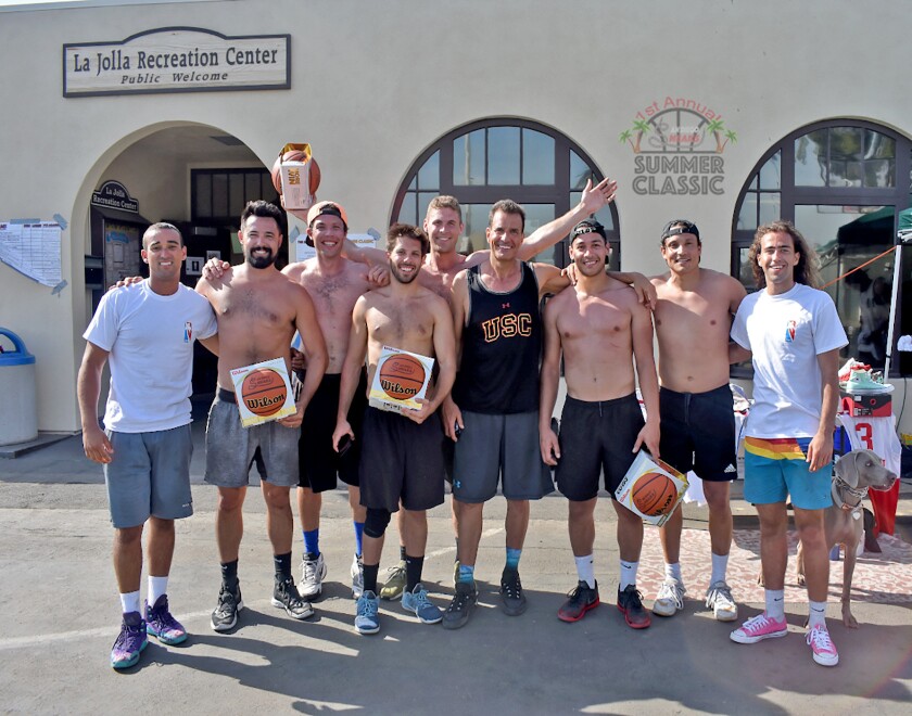 Team members from Crushin’ Dreams, 2018 winners of the inaugural Summer Classic, are presented with Sneaks-branded basketballs by tournament co-founders Sawsun Khodapanah and Tyson Young at La Jolla Rec Center.