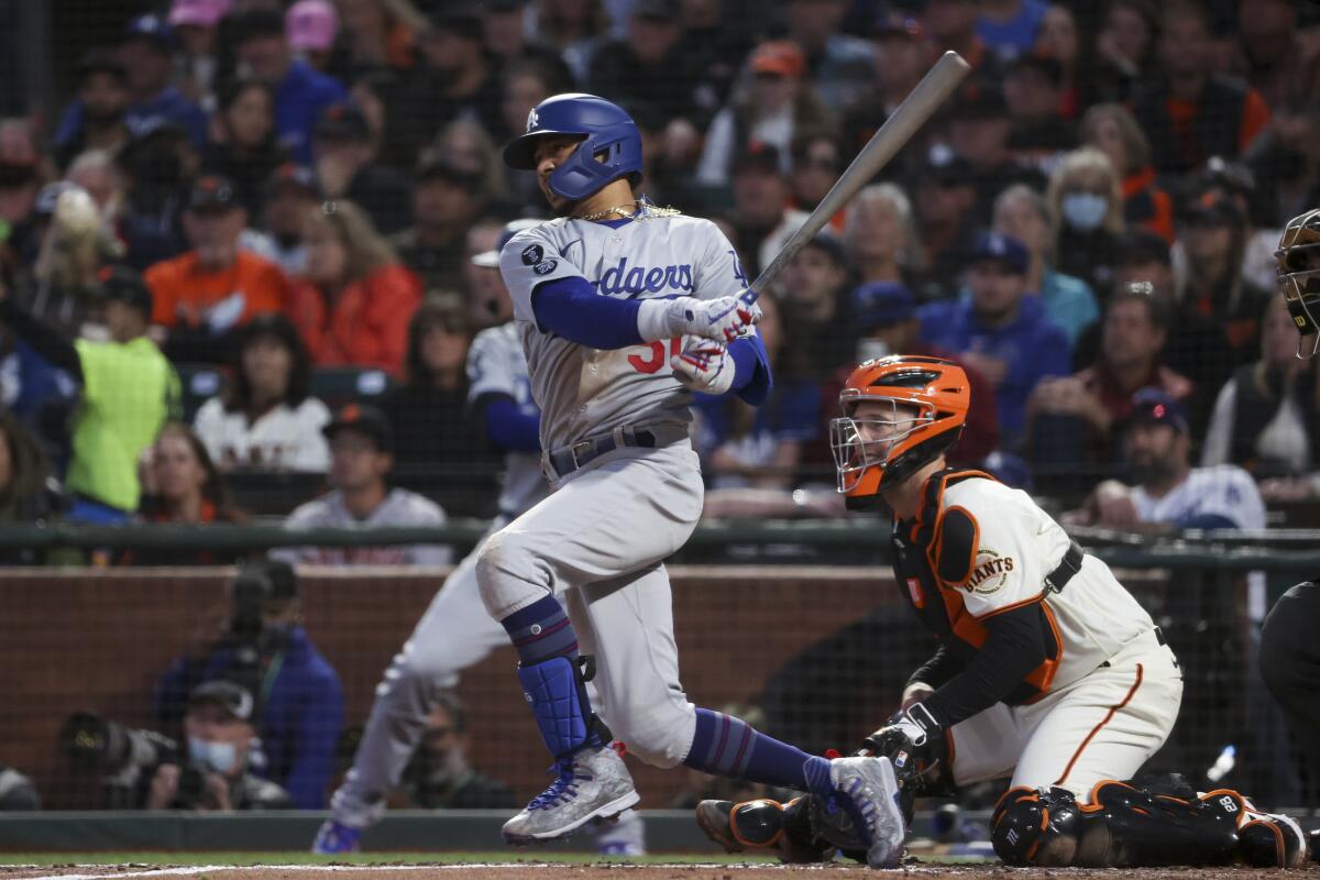 Dodgers leadoff batter Mookie Betts follows through on a run-scoring single.