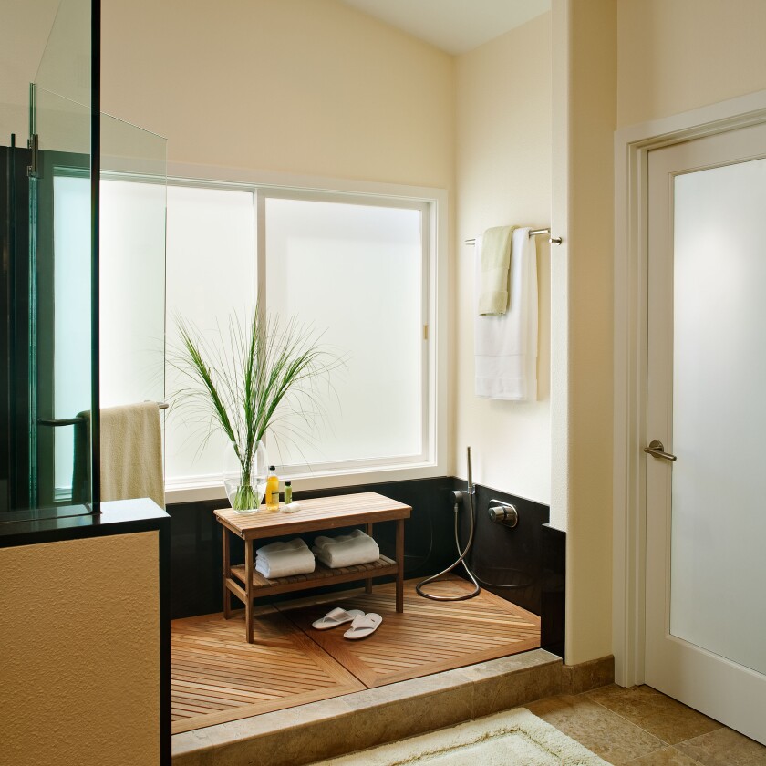A foot and pet wash area has a spray nozzle and a removable slatted teak mat to help keep fur from the drain.