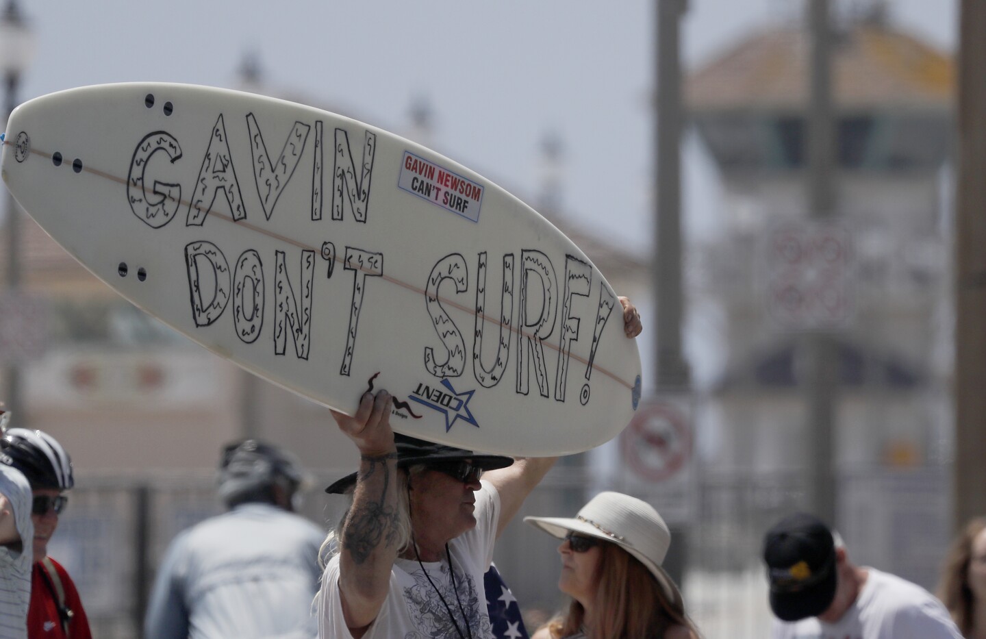 HUNTINGTON BEACH - MAY 2, 2020. Protesters gather near the Huinntington Beach Pier, demanding that California Gov. Gavin Newson lift stay-at-home orders and reopen the California economy, on Saturday, May 2, 2020. Responding to public pressure in recent days, Newson has implied that a gradual reopening following the coronavirus lockdown could begin as early as next week. (Luis Sinco/Los Angeles Times)