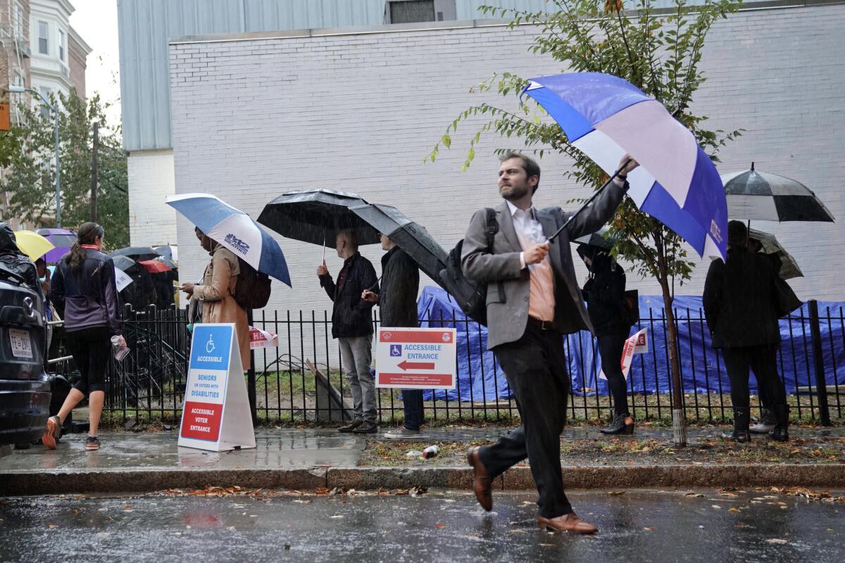 Voters line up in the rain outside Bright Family and Youth Center in the Columbia Heights neighborhood in Washington, D.C., on Tuesday.