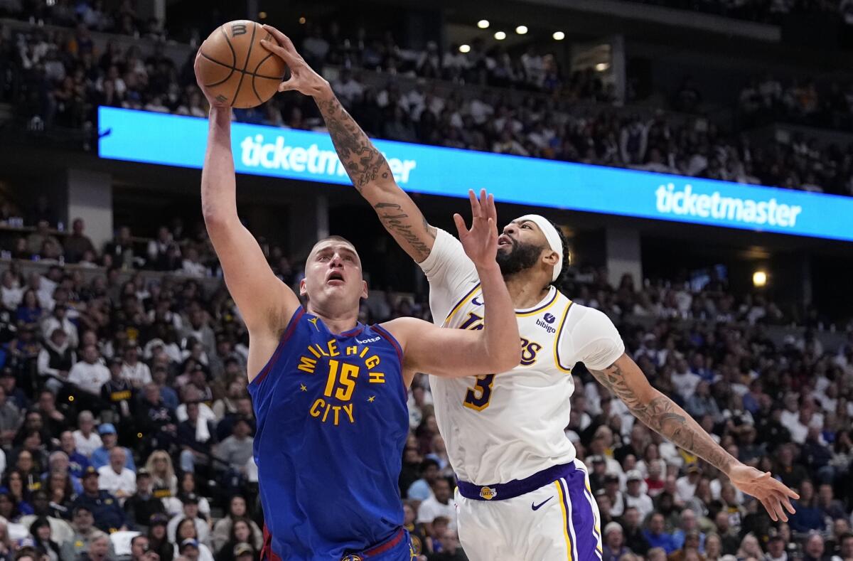 Lakers forward Anthony Davis blocks a shot by Nuggets center Nikola Jokic.