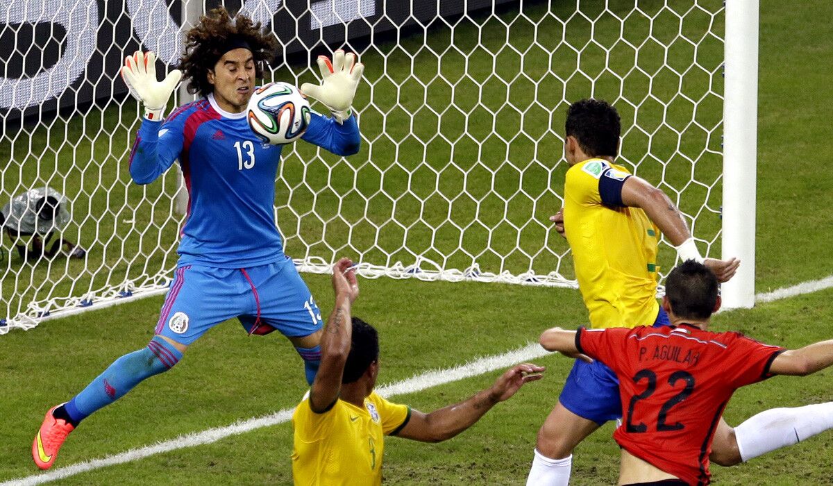 Mexico goalkeeper Guillermo Ochoa blocks a header by Brazil's Thiago Silva late in the second half of their World Cup Group A game Tuesday at Arena Castelao in Fortaleza, Brazil.