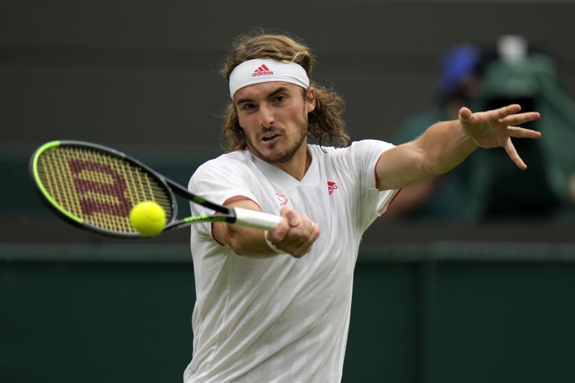 Stefanos Tsitsipas of Greec returns the ball to Frances Tiafoe of the US during the men's singles match on day one of the Wimbledon Tennis Championships in London, Monday June 28, 2021. (AP Photo/Alastair Grant)