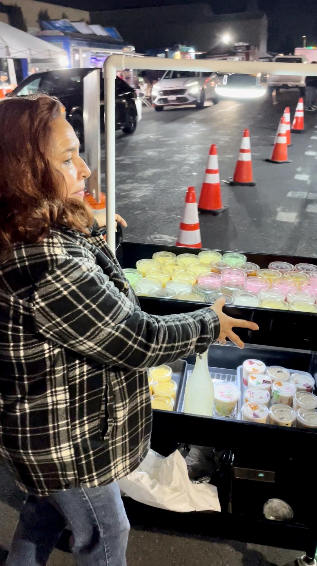 A vendor offers Mexican-style gelatin desserts from her cart at Santa Ana de Noche.