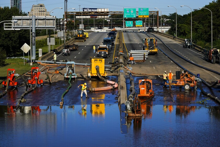 Workers pump water from a flooded section of Interstate 676 in Philadelphia Friday, Sept. 3, 2021 in the aftermath of downpours and high winds from the remnants of Hurricane Ida that hit the area. The cleanup and mourning has continued as the Northeast U.S. recovers from record-breaking rainfall from the remnants of Hurricane Ida. (AP Photo/Matt Rourke)