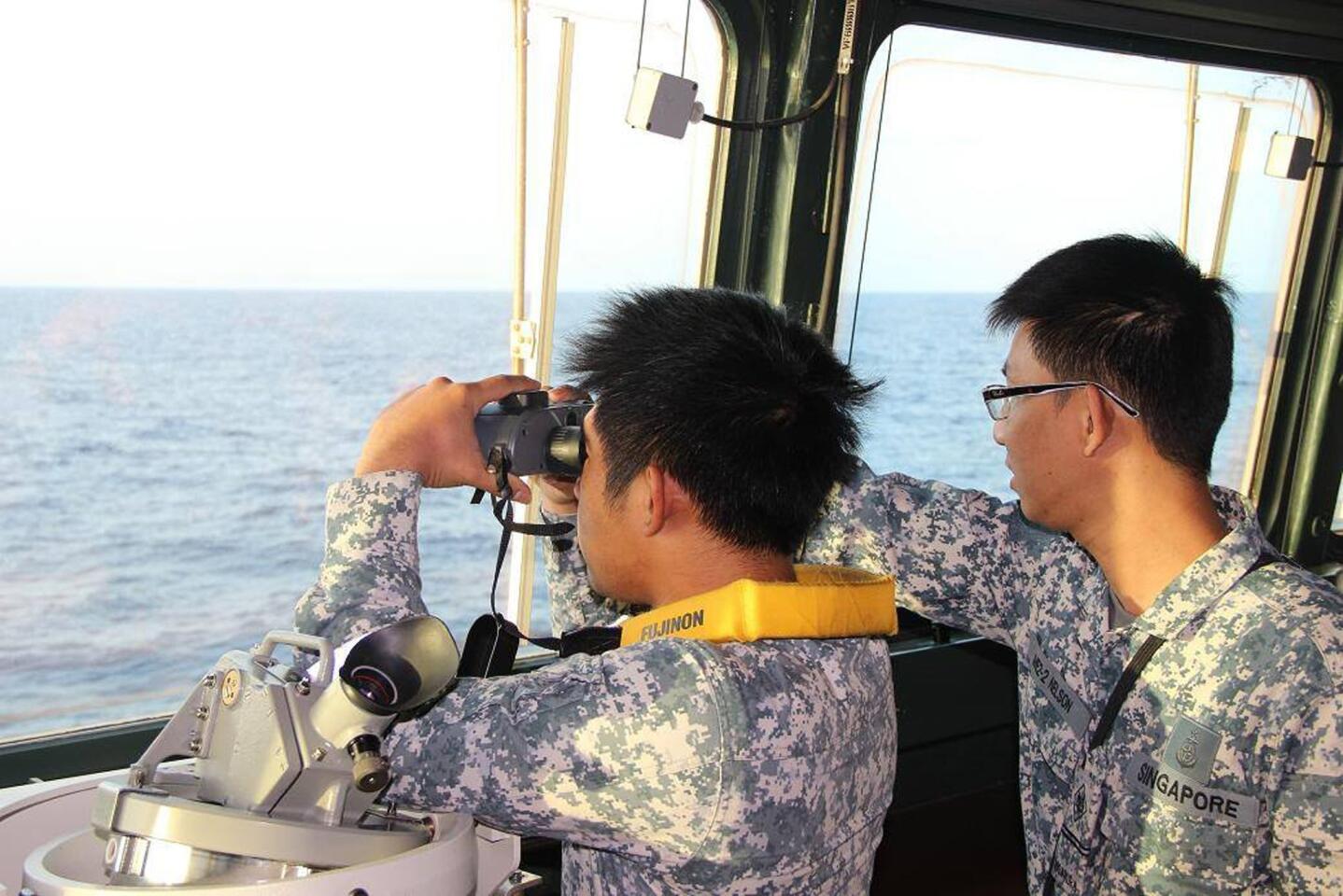 Navy personnel participating in the search and rescue operations, approximately 380 nautical miles (700 kms) north of Singapore, in the South China Sea for the missing Malaysia Airlines flight MH370.