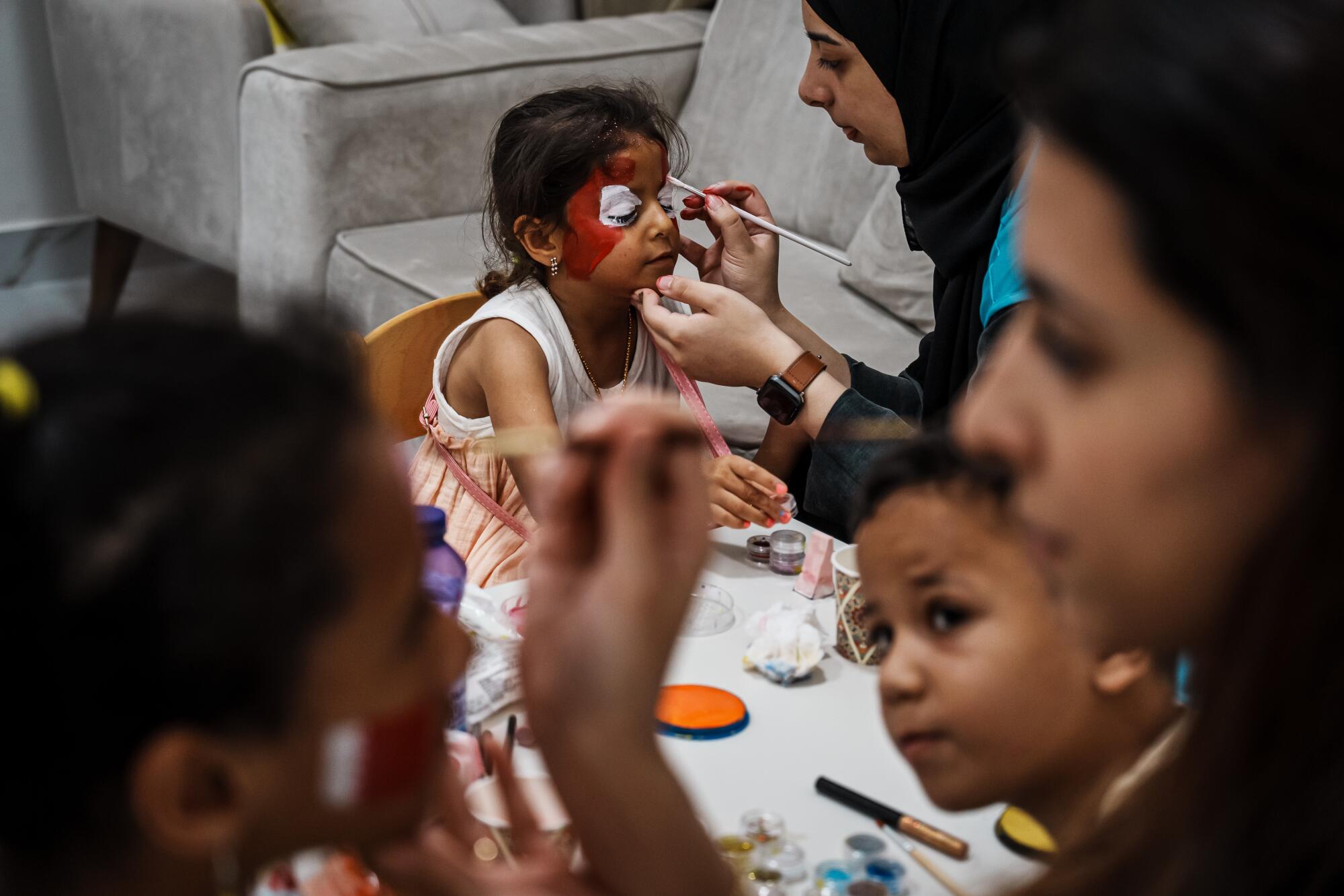 Children have their faces painted. 