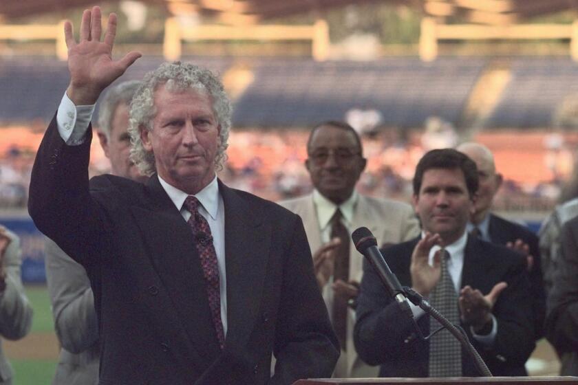 Don Sutton acknowledges applause at the conclusion of a ceremony to retire his number