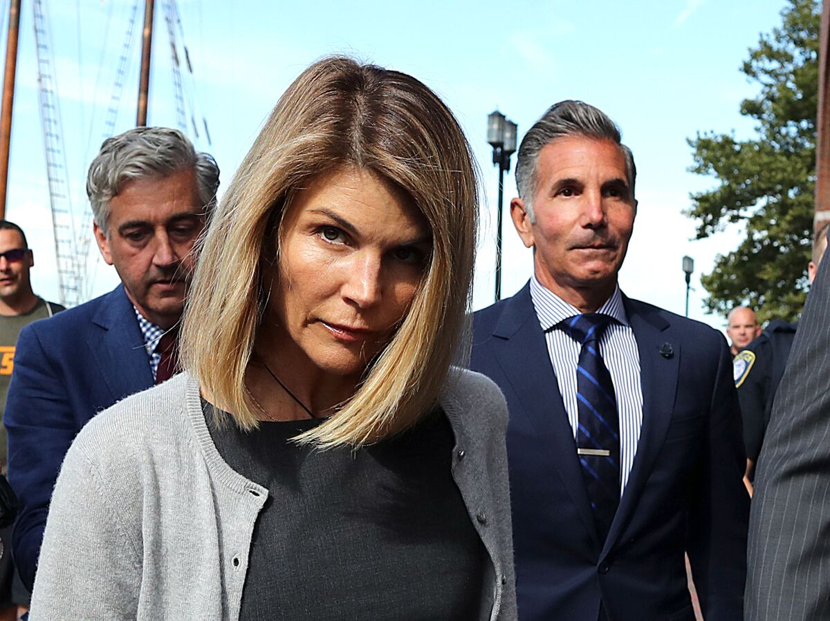 Lori Loughlin and her husband Mossimo Giannulli, right, leave the courthouse in Boston