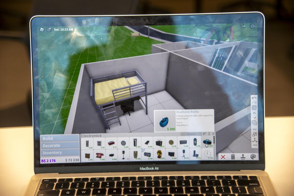 A room is built on a laptop by a team calling itself "The GEICO Guys Who Do Your Home Insurance."