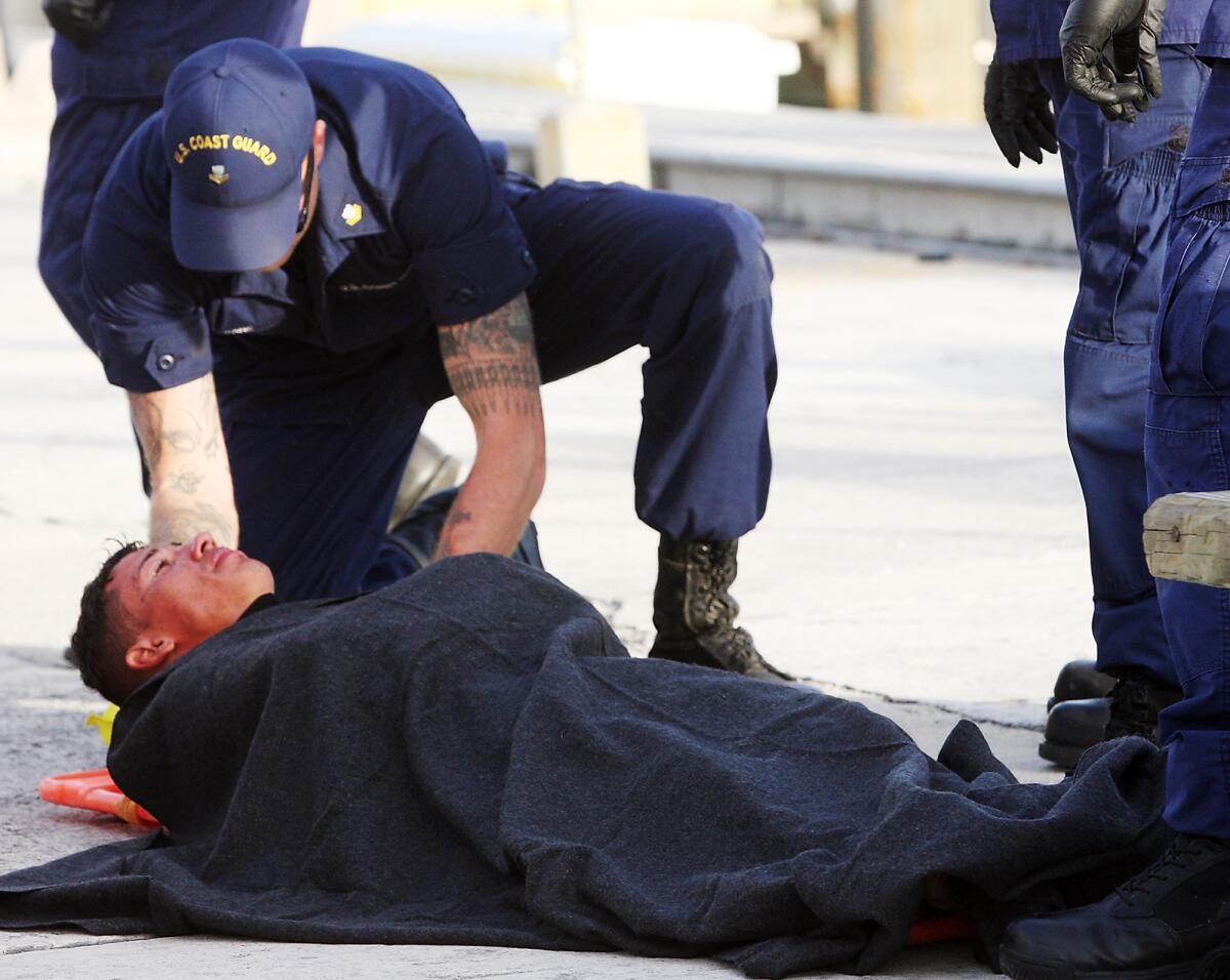 U.S. Coast Guard members in Key West await an ambulance for the third windsurfer who left Cuba last week for Florida. The unidentified man had spent four days at sea before being rescued.