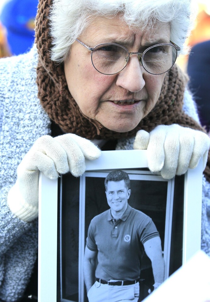 Mary Cardona holds a photo of Huell Howser as she and hundreds of others gather to celebrate and remember the life of television host Huell Howser during a memorial tribute at Griffith Observatory on Tuesday. [For the record, Jan. 19, 5:19 p.m.: An earlier version of this caption misidentified Mary Cardona as Mary Cardinella.]