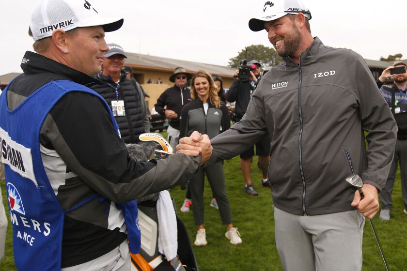 Marc Leishman celebrates with caddie Matty Kelly, left, after winning the Farmers Insurance Open on Jan. 26, 2020.