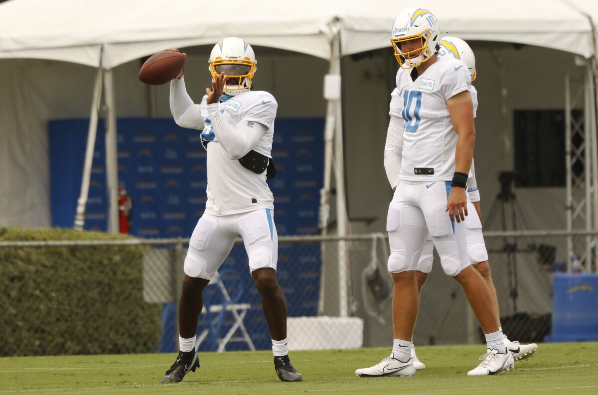 Chargers quarterback Tyrod Taylor throws a pass in practice in front of rookie Justin Herbert