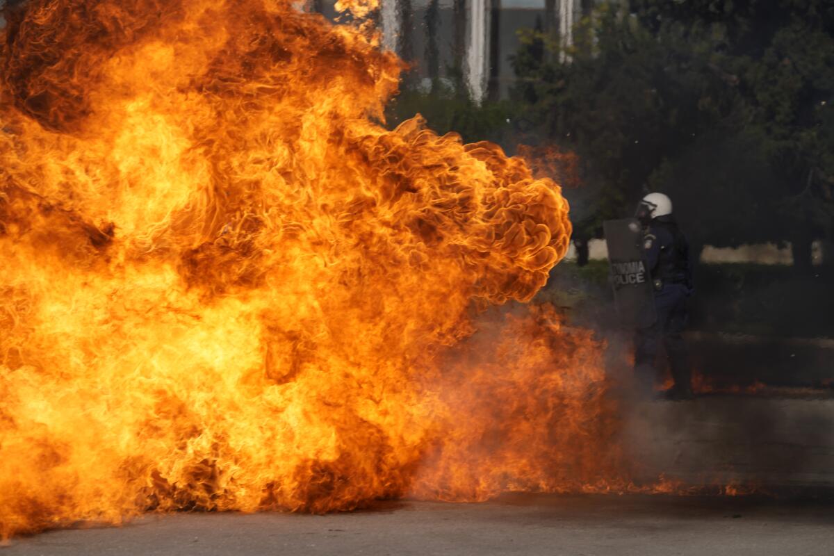 A Molotov cocktail explodes near riot police outside the Greek Parliament during clashes in Athens, Greece, Wednesday, Nov. 9, 2022. Thousands of protesters are marching through the streets of Athens and the northern Greek city of Thessaloniki as public and some private sector workers walk off the job for a 24-hour general strike against price hikes. (AP Photo/Petros Giannakouris)