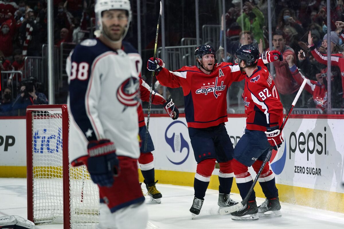 Columbus Blue Jackets center Boone Jenner (38) skates away as Washington Capitals center Evgeny Kuznetsov (92) celebrates his goal with Nicklas Backstrom (19) during the second period of an NHL hockey game Tuesday, Feb. 8, 2022, in Washington. (AP Photo/Evan Vucci)
