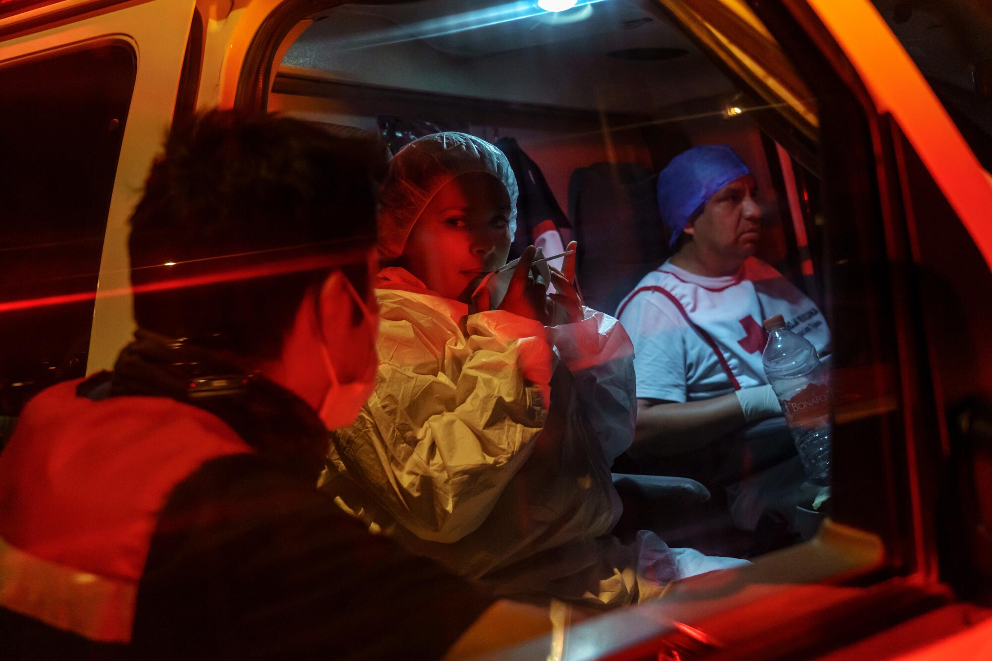 Dr. Francisco Tenorio, left, speaks a fellow paramedic to give them an update about a patient who was on their last hours of life, as family members initially asked for an ambulance but decided against it because of personal reasons, in Tijuana, Mexico, on May 3, 2020.