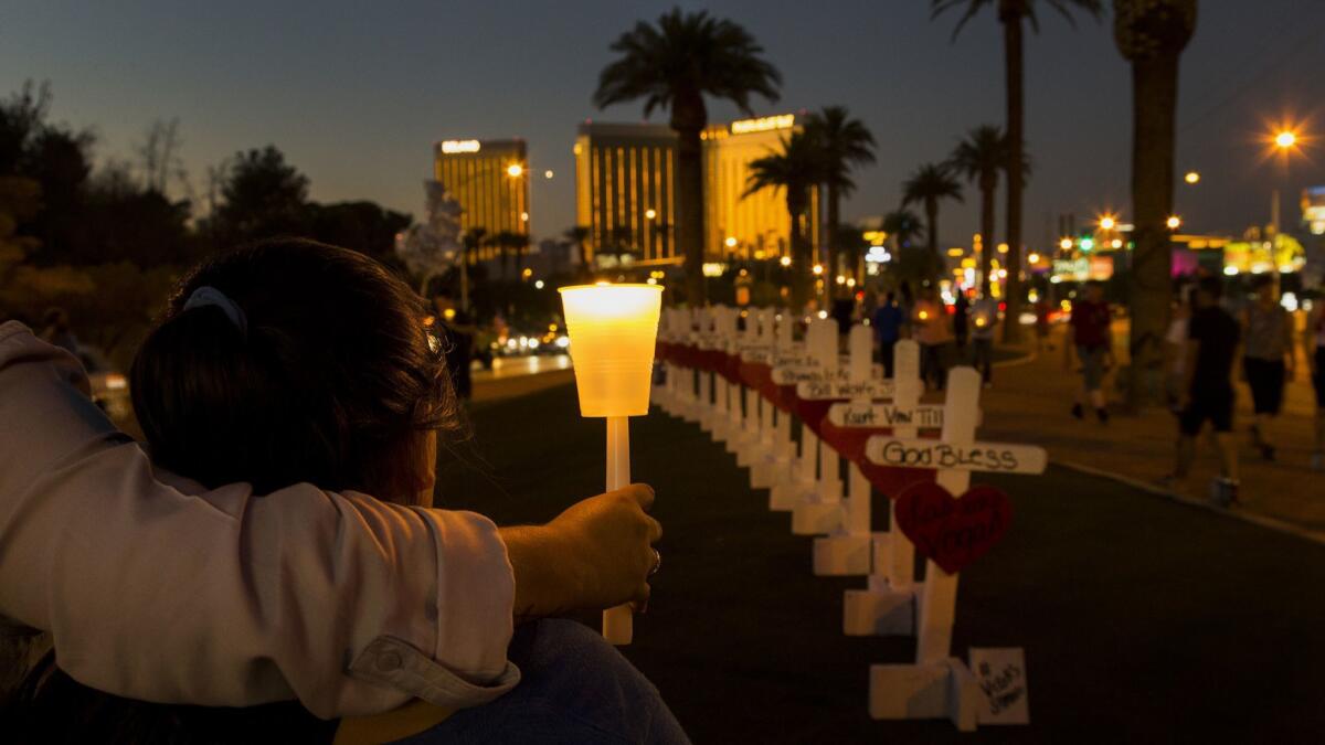 With wooden crosses bearing the names of those killed in the Las Vegas mass shooting, community members gather with candles to pay tribute on Oct. 5, 2017, four days after the massacre.