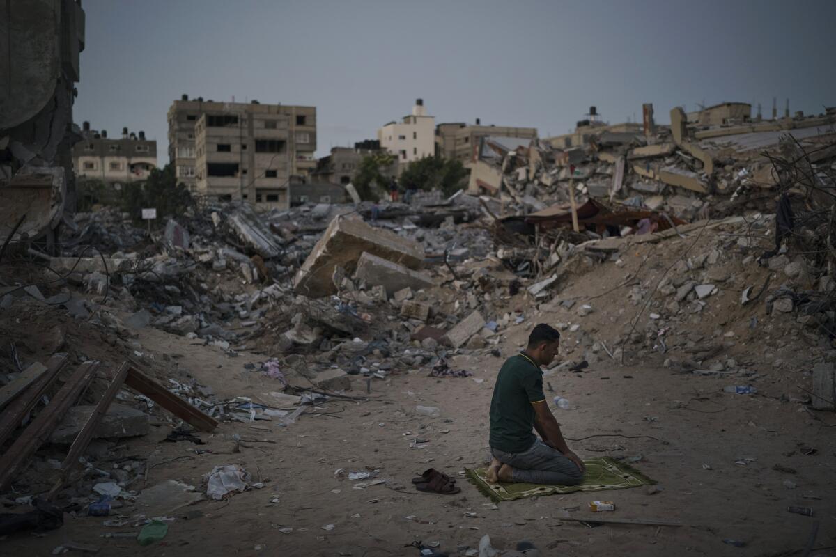 ARCHIVO - Un palestino reza entre los escombros de la casa de su familia, destruida