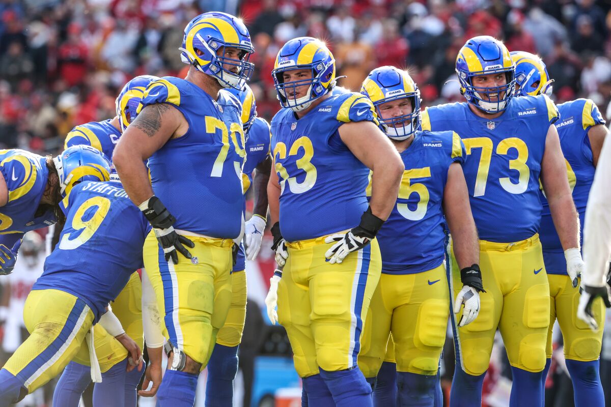 Rams listen as quarterback Matthew Stafford gives instructions in the huddle.