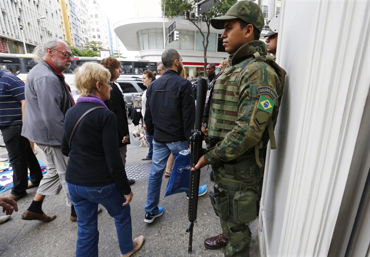 A Brazilian soldier stands guard on a corner in Copacabana.