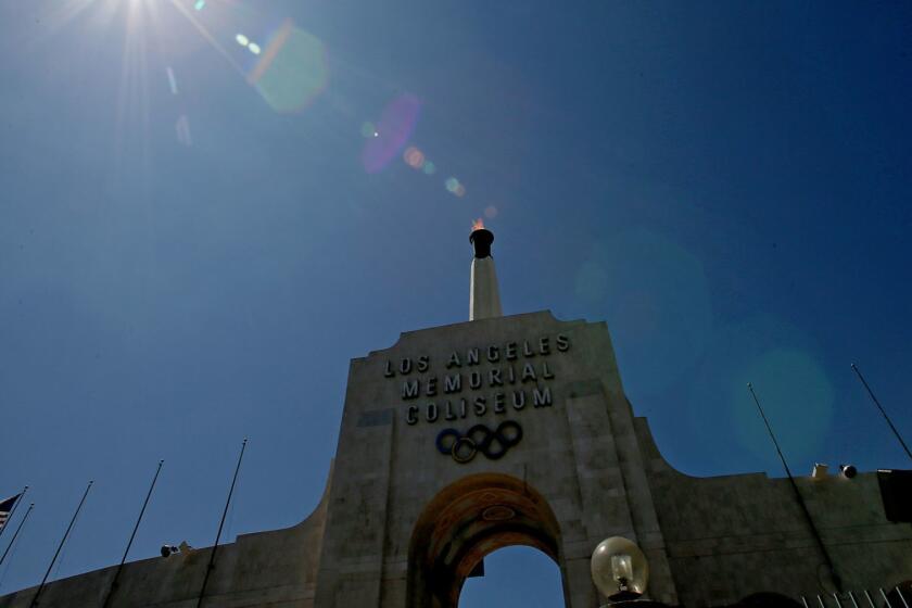 LOS ANGELES, CALIF. - SEP. 13, 2017. The Olympic torch burns atop the Los Angeles Memorial Coliseum after the city was officially awarded the rights to host the 2028 Olympic Games on Wednesday, Sep. 13, 2017. (Luis Sinco/Los Angeles Times)
