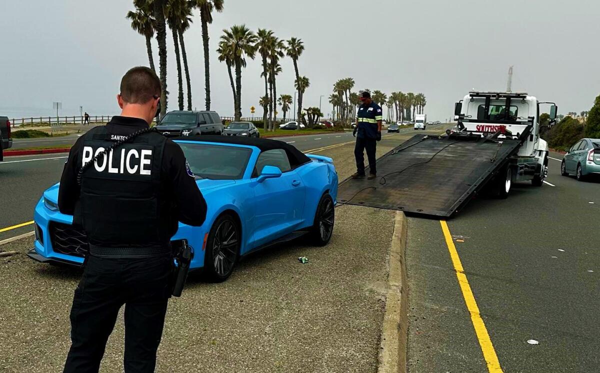 Police tow a "Rapid Blue" Chevrolet Camaro Monday that was involved in a multiagency police pursuit that ended on PCH.