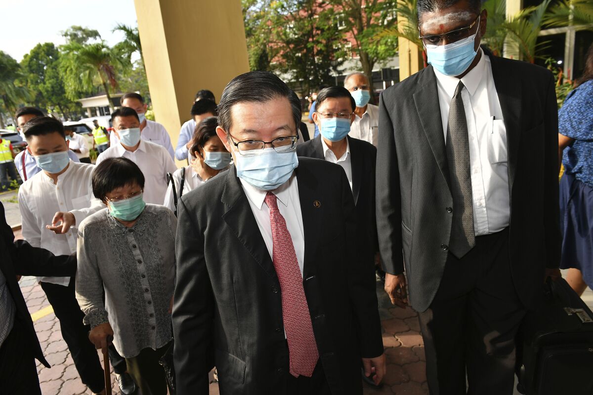 Malaysian former Finance Minister and Penang Chief Minister Lim Guan Eng, center, arrives at courthouse in Butterworth, Malaysia, Monday, Aug. 10, 2020. Lim pleaded not guilty to a second graft charge relating to a $1.5 billion undersea tunnel project. Lim has slammed the charges as political persecution by the new government. (AP Photo/Gary Chuah)