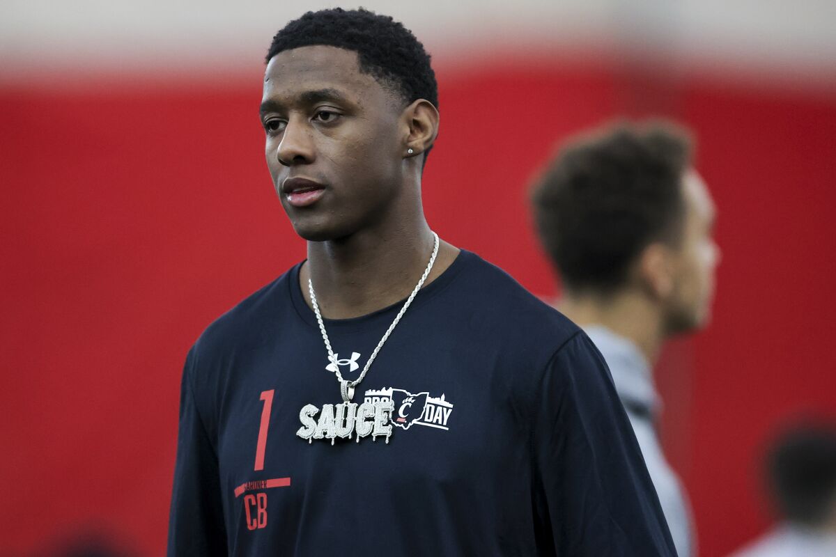Defensive back Ahmad Gardner stands on the field wearing a large necklace featuring his nickname, Sauce