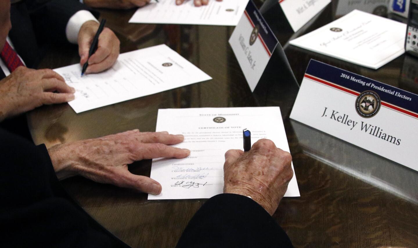 Members of the Mississippi Electoral College sign Certificates of Vote in the process of formally casting their electoral votes in the 2016 general election for president and vice president of the United States at the Capitol in Jackson, Miss.