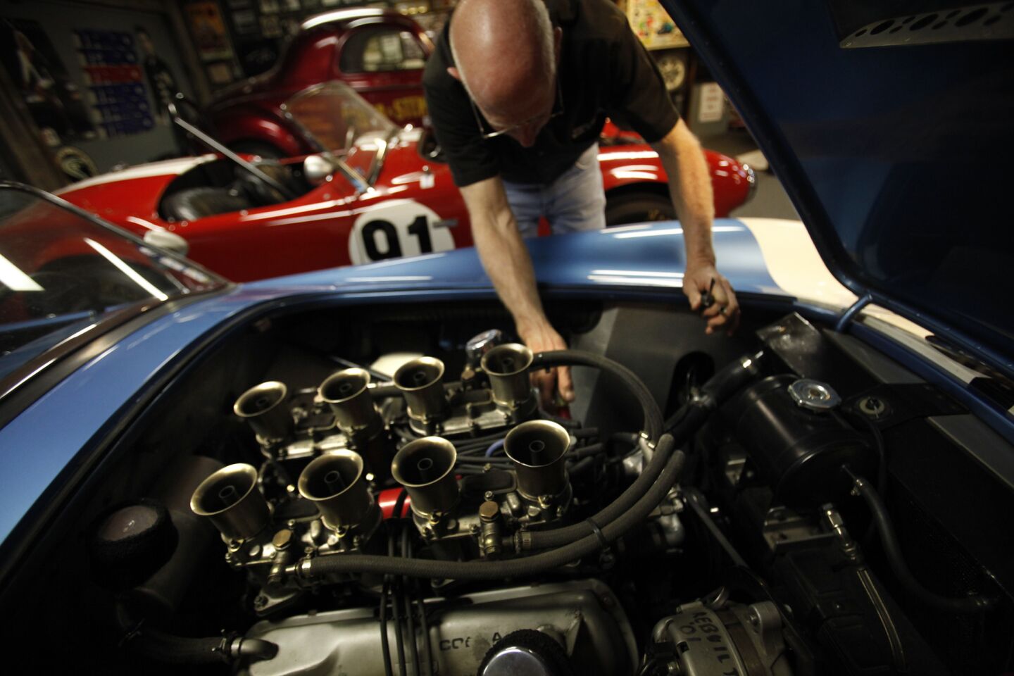 Park checks the hoses of a Cobra he will take to Pebble Beach. This particular car is worth about $2 million.