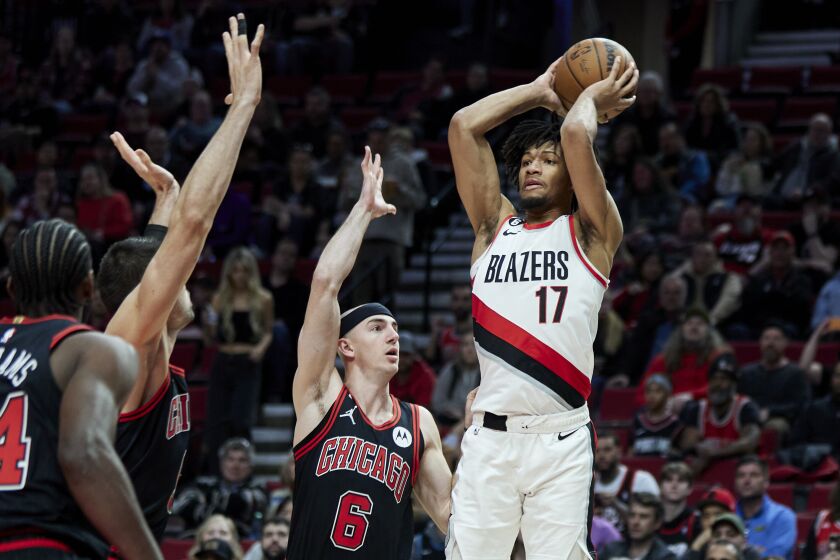 Portland Trail Blazers guard Shaedon Sharpe, right, looks to pass the ball away from Chicago Bulls guard Alex Caruso during the first half of an NBA basketball game in Portland, Ore., Friday, March 24, 2023. (AP Photo/Craig Mitchelldyer)