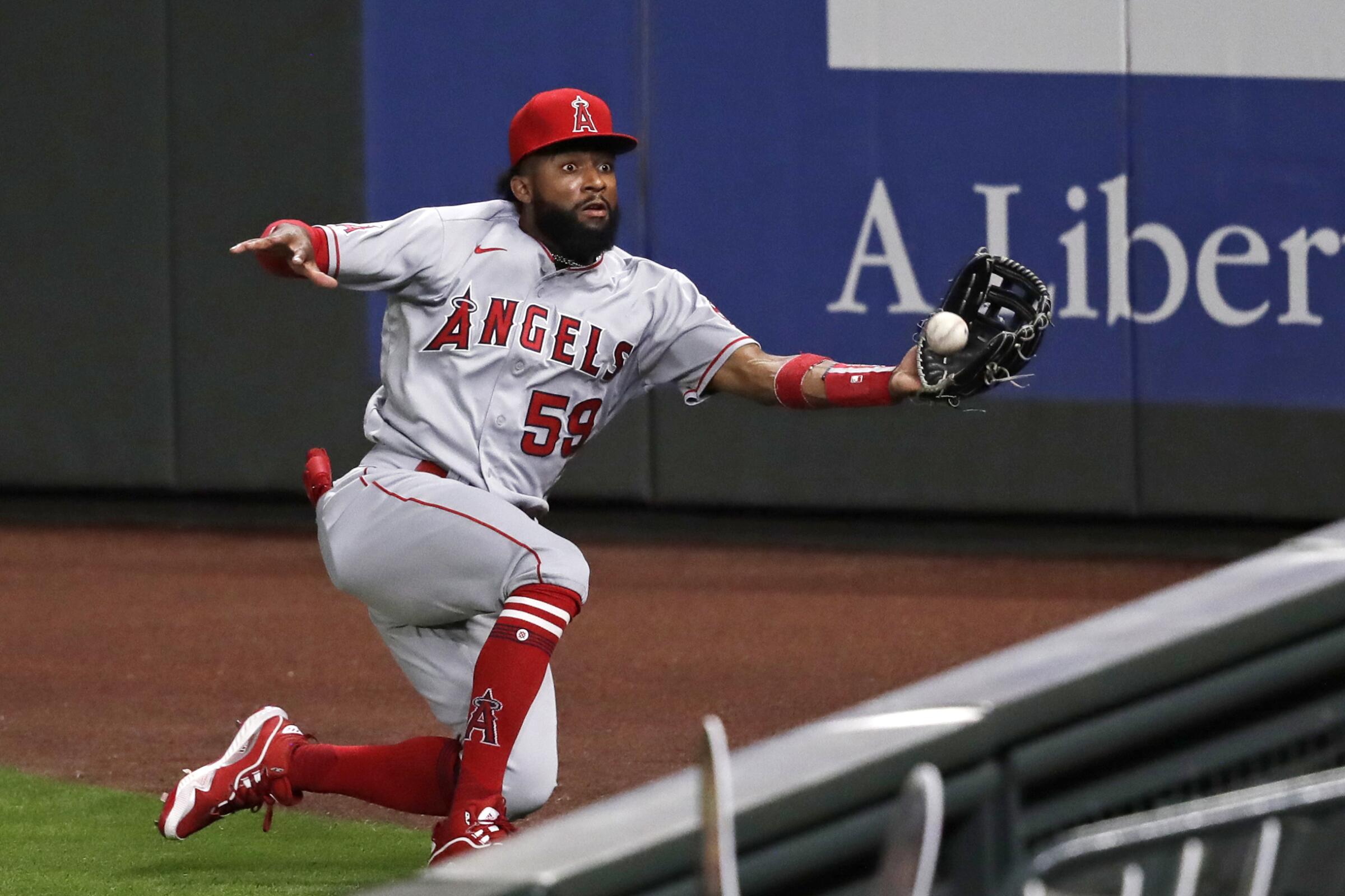 Los Angeles Angels right fielder Jo Adell tries to chase down a deep fly ball.