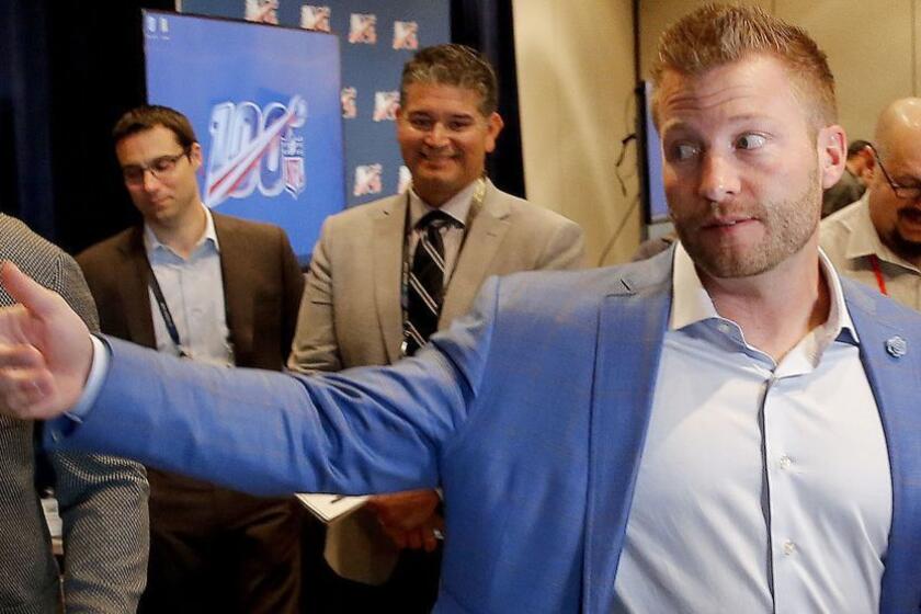 Los Angeles Rams head coach Sean McVay speaks to the media as he and Los Angeles Chargers head coach Anthony Lynn, left, view the new Los Angeles Stadium at Hollywood Park on a monitor during the annual NFL football owners meetings, Tuesday, March 26, 2019, in Phoenix. (AP Photo/Matt York)