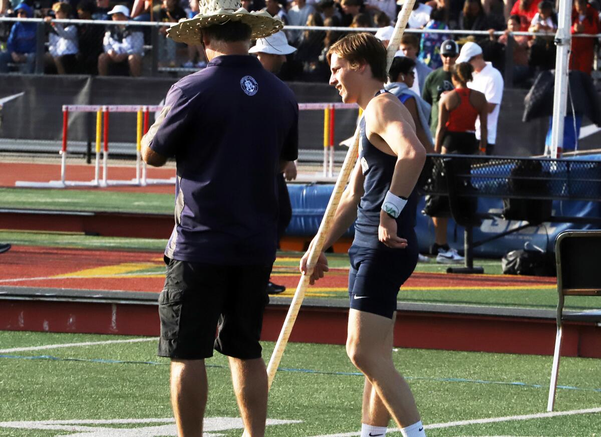 Newport Harbor's Leo Davis talks with his coach Fritz Howser after his pole vault attempt on Saturday.
