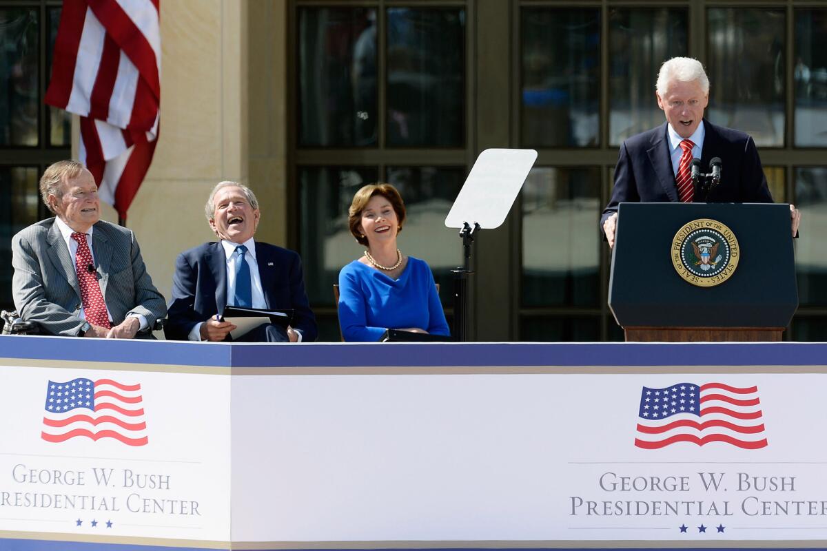 President George W. Bush laughs during President Clinton's speech as President George H.W. Bush and former First Lady Laura Bush look on during the opening ceremony of the George W. Bush Presidential Center in Dallas.