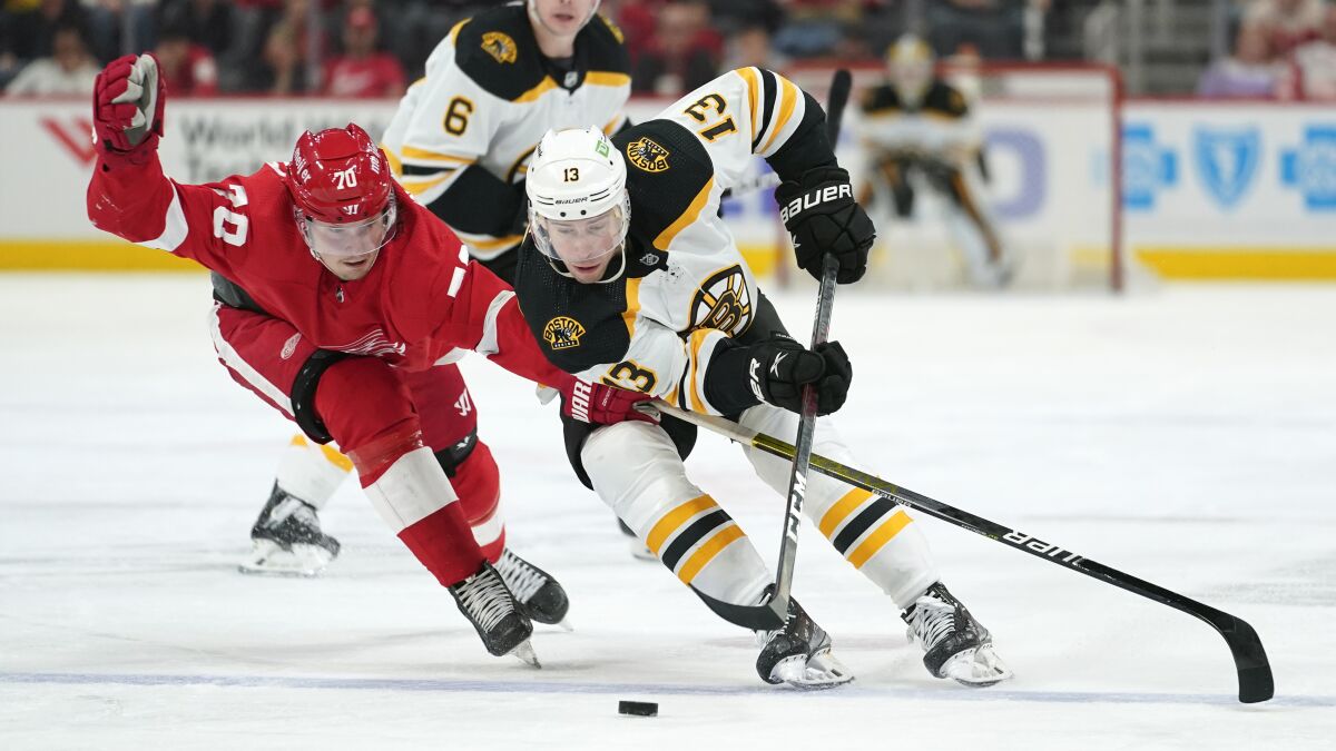 Detroit Red Wings center Oskar Sundqvist (70) defends Boston Bruins center Charlie Coyle (13) in the third period of an NHL hockey game Tuesday, April 5, 2022, in Detroit. (AP Photo/Paul Sancya)