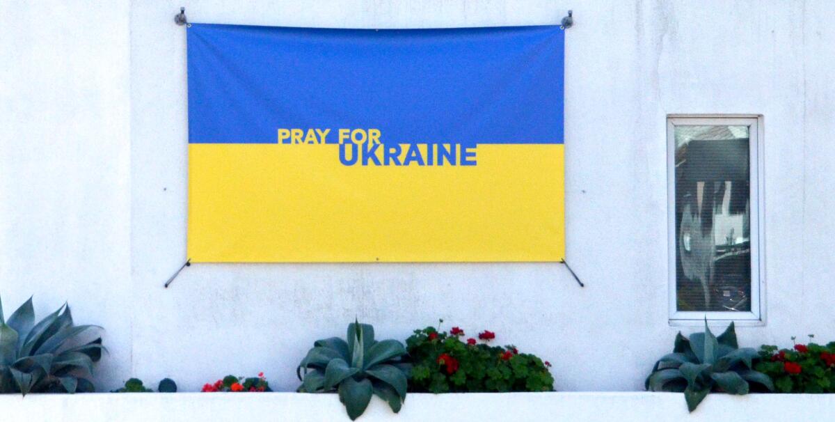One of two large banners bearing the Ukraine flag blue and yellow colors is attached exterior walls at St. James.