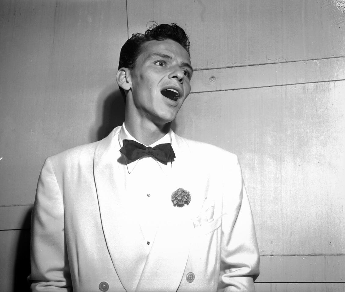 Frank Sinatra sings a few notes for photographers backstage before performing at the Hollywood Bowl.