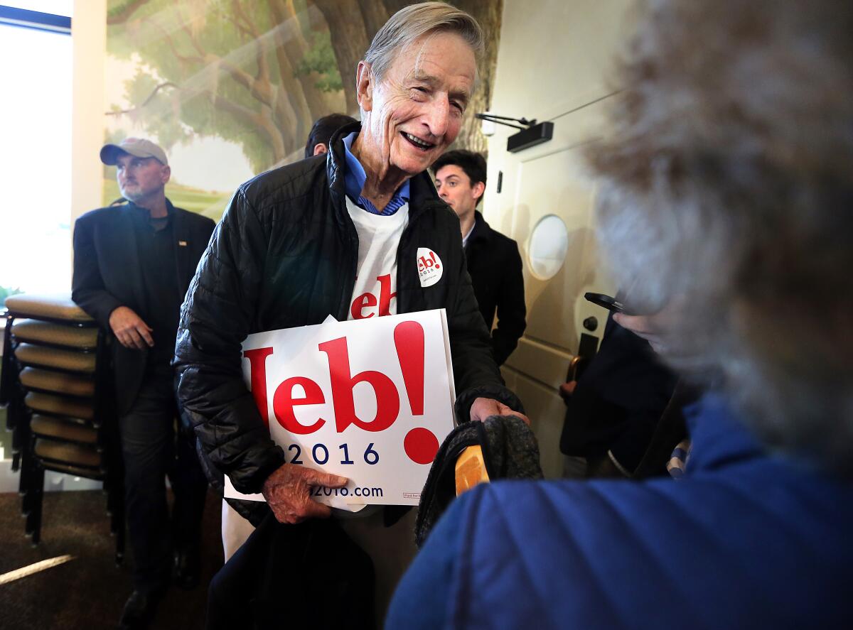 Jonathan Bush smiles and holds a "Jeb 2016!" sign