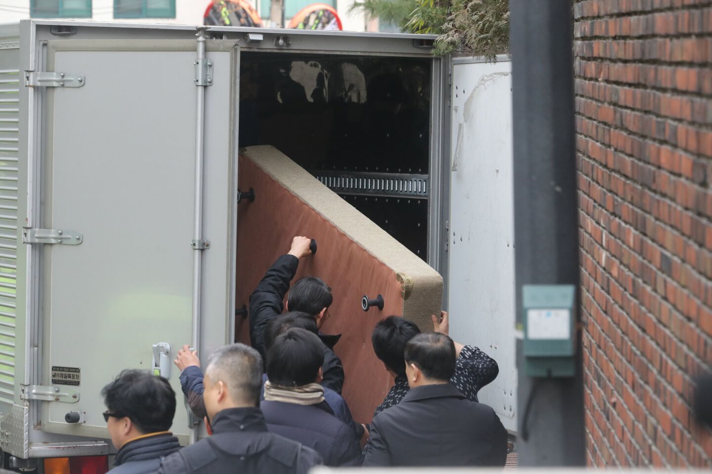 Workers move a bed from the presidential office to Park Geun-hye's private residence in Samseong-Dong in southern Seoul.