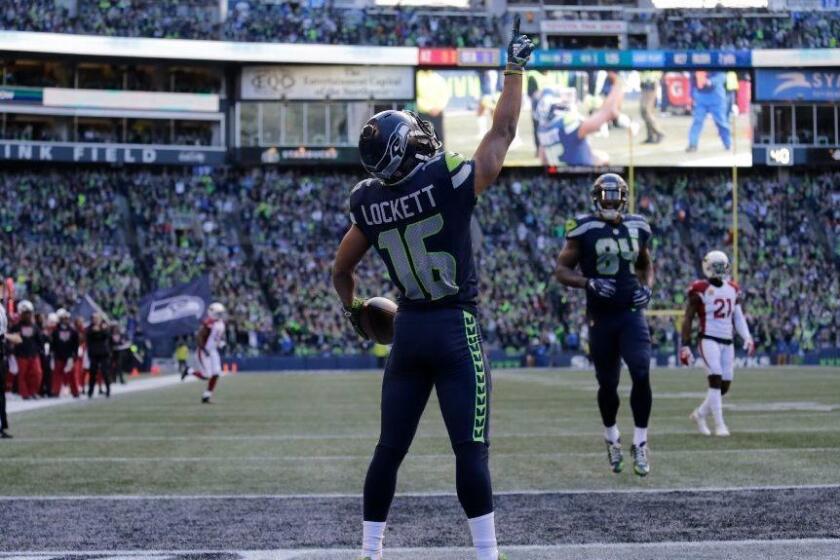 Seattle Seahawks' Tyler Lockett (16) reacts after flipping his way into the end zone on a 29-yard touchdown reception against the Arizona Cardinals during the first half of an NFL football game, Sunday, Dec. 30, 2018, in Seattle. (AP Photo/John Froschauer)