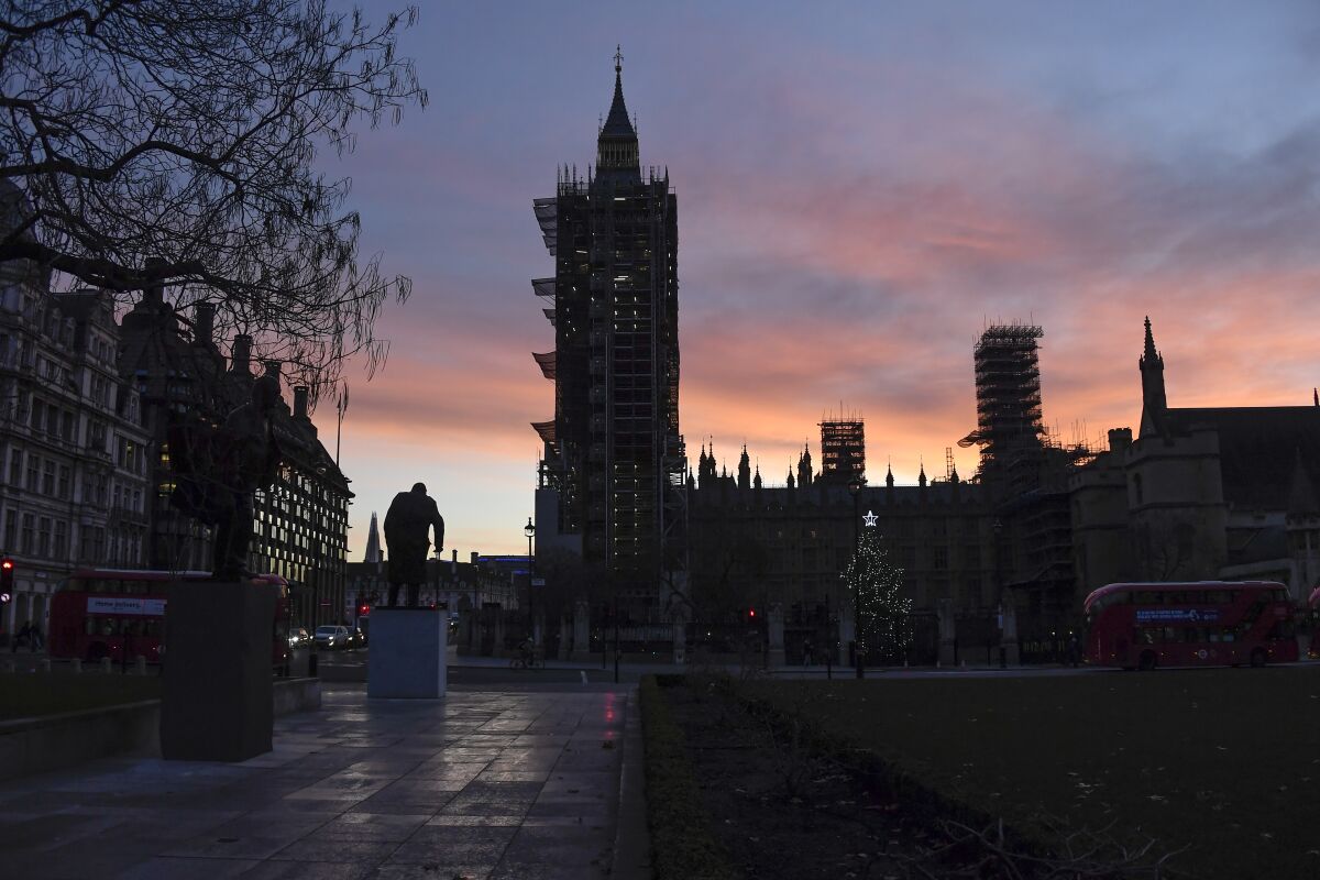 The sun rises over the Parliament Square, in London, Saturday, Dec. 5, 2020. (AP Photo/Alberto Pezzali)